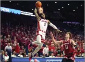  ?? RICK SCUTERI — THE ASSOCIATED PRESS ?? Arizona's Caleb Love (2) dunks over Wisconsin's Max Klesmit (11) during the first half Saturday in Tucson, Ariz.