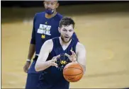  ?? CARLOS OSORIO — THE ASSOCIATED PRESS ?? Michigan coach Juwan Howard, top, looks on as center Hunter Dickinson takes an inbound pass during practice during media day, Oct. 15.