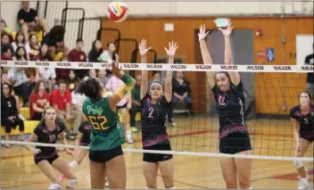  ?? PHOTO BY HOWARD FRESHMAN ?? Wilson's Sadie Calderon (2) and Babi Gubbins (12) defend a hit by Poly's Saniya Kimbrough (62) in Tuesday's match.