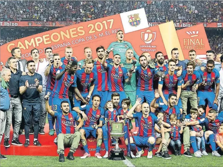  ??  ?? El capitán Andrés Iniesta recogió la Copa del Rey y la bajó al césped, donde el Barcelona posó con el trofeo y celebró el título