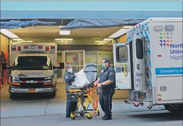  ?? Angela Weiss AFP/Getty Images ?? PARAMEDICS prepare a gurney at Mt. Sinai Hospital in New York on Wednesday. As hospitals are overwhelme­d by coronaviru­s cases, the U.S. is accepting emergency medical supplies from China and Russia.