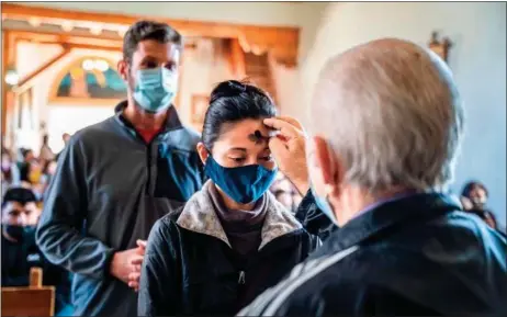  ?? NATHAN BURTON/Taos News file photo ?? Parishione­rs are marked with ash for Ash Wednesday at San Francisco de Asís Catholic Mission Church in March 2022.