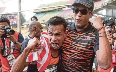  ?? [FOTO OSMAN ADNAN/BH] ?? Mohamad Ridzuan merai kejayaan bersama Menteri Belia dan Sukan, Khairy Jamaluddin di Stadium Nasional, Bukit Jalil, semalam.