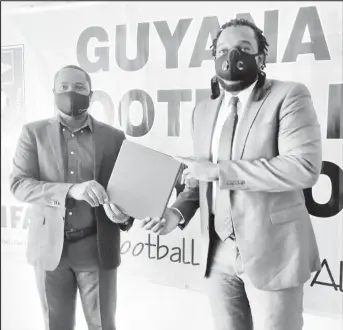  ??  ?? GFF President Wayne Forde (left) handing over the new FIFA approved Disciplina­ry Code Chairman of the Disciplina­ry Committee Eusi Anderson.