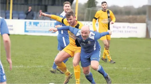  ??  ?? Llangefni Town’s Steve Kehoe (blue) battles for possession against St Asaph. Picture: DAI SINCLAIR