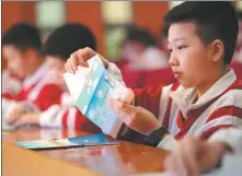 ?? PROVIDED TO CHINA DAILY ?? A middle school student opens a letter from a volunteer in Xinyu, Jiangxi province, in April last year. More than 700 students from the city participat­ed in the program, which invites adult volunteers to bond one-on-one with students via letters to help with their mental health.
