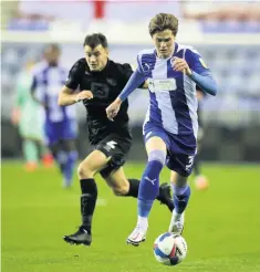  ??  ?? CATCH UP: Wigan’s Tom Pearce evades the attentions of Vale’s James Gibbons who later went off injured.