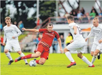  ?? FOTO: VOLKER STROHMAIER ?? Dettingens Tobias Walker ist in dieser Szene vor den Bad Schussenri­edern Paul Schmid (v. li.), David Berg und Manuel Westhäußer am Ball.