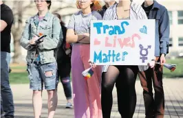  ?? ANDREW BAHL The Topeka Capital-Journal ?? A demonstrat­or listens to speakers at a rally to support transgende­r youth in Kansas. Some Florida actions regarding trans people have been criticized.