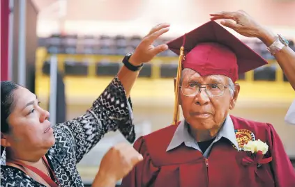  ?? PHOTOS BY GABRIELA CAMPOS/THE NEW MEXICAN ?? Christy Abeyta, a history teacher at Santa Fe Indian School, helps adjust World War II veteran Clemente Otero’s graduation cap before he receives his honorary diploma Friday. The school wanted to recognize his service, as the 92-year-old was drafted before he could graduate.