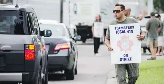  ?? CHRISTOPHE­R KATSAROV, CP ?? Workers picket the drop-off area at Pearson Internatio­nal Airport on Friday.