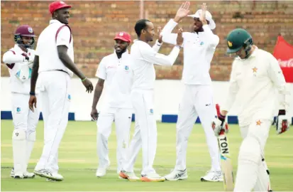  ??  ?? West Indies players celebrate the dismissal of Malcolm Waller for a duck