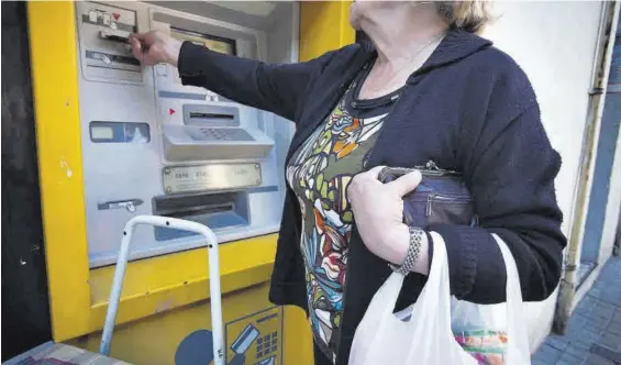  ?? CEDIDAS ?? Una mujer saca dinero de un cajero, en una foto de archivo.