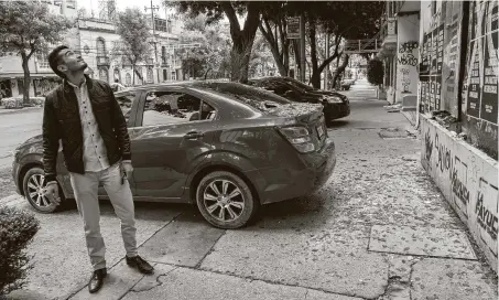  ?? Claudio Cruz / Tribune News Service ?? A man looks at a building after his car was damaged by a broken glass and objects that fell on it in Mexico City during the earthquake. The quake was centered near the southern resort of Huatulco and killed at least four people.