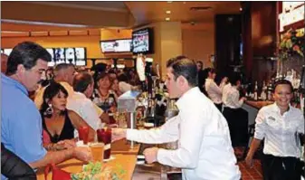  ?? MEDIANEWS GROUP FILE PHOTO ?? The Movie Tavern chain of theaters has been sold — including three in the tri-county area. This file photo shows people at the bar and dining area at the Movie Tavern at Providence Town Center in July 2011, getting something to eat and drink before their movie.