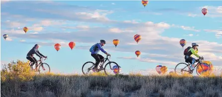  ?? JIM THOMPSON/JOURNAL ?? Bicyclists take to the bike paths to avoid the traffic jams during the Albuquerqu­e Internatio­nal Balloon Fiesta in 2016.