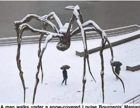  ?? EPA ?? A man walks under a snow-covered Louise Bourgeois’ Maman bronze sculpture in front of Guggenheim Bilbao Museum during a snowstorm in Spain yesterday.