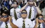  ?? ASSOCIATED PRESS ?? Belen Jesuit Preparator­y School students look through solar glasses as they watch the eclipse Monday in Miami.