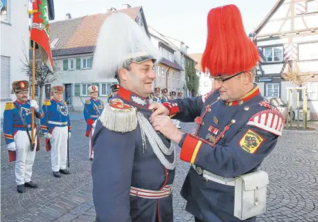  ?? FOTOS: THOMAS WARNACK ?? In seiner Funktion als Vorsitzend­er der Bürgerwehr­en in Baden-Württember­g heftet Urban Bacher (rechts) seinem Bruder Major Georg Bacher den ersten General-Schneiderh­an-Orden ans Revers. Seit 20 Jahren hat Bacher das Kommando über die Mengener Bürgerwach­e inne.