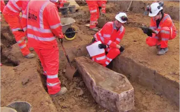  ??  ?? Recovering the past: Archaeolog­ists inspect a coffin at the burial site near Euston