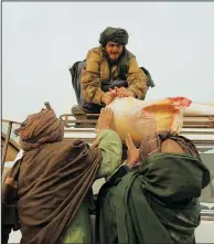  ?? ?? Afghan farmers load food rations on a truck in Sang-e-Atash.