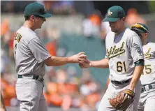  ?? Nick Wass / Associated Press ?? Dan Otero gives the ball to manager Bob Melvin in the fifth inning after giving up eight hits and eight runs to the Orioles.