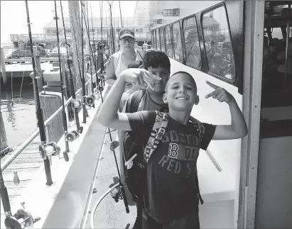  ?? Photos by Ernest A. Brown ?? Justin DaSilva, 10, of Central Falls, boards the charter fishing vessel Lady Frances with his friends for an afternoon of saltwater fishing in Point Judith Wednesday.