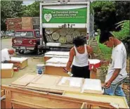  ?? MORNING JOURNAL FILE ?? Lorain County Habitat for Humanity driver Neal Rutledge, left, and volunteers Juan Melendez, center, and Angelys Melendez paint cabinets on July 19, 2015.