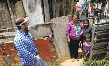  ?? Rebecca Blackwell Associated Press ?? IN MEXICO, where the pandemic has caused hardship, a plan for TV learning has sparked confusion and frustratio­n. Above, Luis Gutierrez delivers donated items in June to Janete Navarro Perez in Piedra Grande.