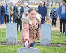  ??  ?? Students from Middleton Regional High School placed poppies on the headstones at the graves of Commonweal­th airmen killed in training exercises during the Second World War. The airmen came from Canada, New Zealand, Great Britain, and Australia and trained out of Greenwood. A Nov. 5 ceremony was part of the program ‘No Stone Left Alone.’