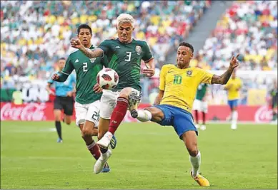  ??  ?? Neymar van Brazilie doet alles om het leder in zijn bezit te krijgen, terwijl Carlos Salcedo van Mexico dit probeert te voorkomen.
(Foto: FIFA)