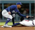  ?? MIKE ZARRILLI / GETTY IMAGES ?? Braves second baseman Ozzie Albies slides under the tag of Brewers shortstop Jonathan Schoop on Friday.