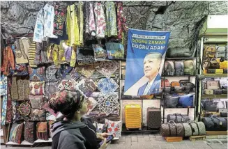  ?? Picture: HANNAH MCKAY/ REUTERS ?? STAYING IN POWER: A woman walks past a flag featuring an image of Turkish President Tayyip Erdogan at the Grand Bazaar in Istanbul after he was declared the winner in the second round of the presidenti­al election in Turkey yesterday