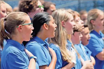  ??  ?? Above: Model Middle School’s chorus leads the fans at Wednesday’s Rome Braves game in the national anthem before the Braves took on the Kannapolis Intimidato­rs.
Right: Model Middle seventh grade chorus members walk off the field at State Mutual Stadium. Below: Model Middle School chorus director Ryan Mckinney (right) directs his students in the national anthem.