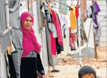  ?? AP PHOTO ?? Syrian refugees stand outside during a visit by U.N. refugee chief Filippo Grandi to the Zaatari Syrian Refugee Camp, in Mafraq, Jordan on Monday. Grandi said the number of Syrian refugees deported from Jordan to their war-ravaged homeland has...