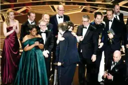  ??  ?? Mexican director Guillermo del Toro (C) stands on stage with his cast and crew after he won the Oscar for Best Film for ‘The Shape of Water.’ (AFP)