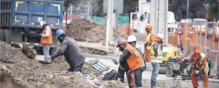  ??  ?? ► Personas extranjera­s trabajando en una empresa de construcci­ón, en Santiago.