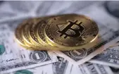  ??  ?? Bitcoin coins placed on dollar banknotes. The crypto-currency’s price has surged to about $13 000 in Zimbabwe, where trade in bitcoin is booming.