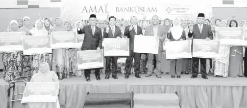  ?? — Bernama photo ?? Mohd Muazzam Mohamed poses for a photo with recipients of Bank Islam’s business tithe yesterday.