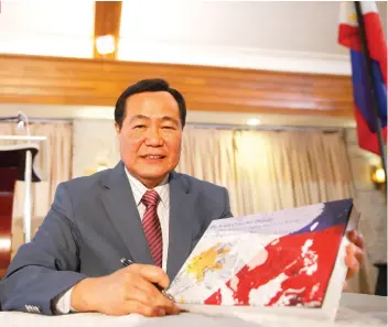  ?? / AP FOTO ?? BOOK. Supreme Court Senior Associate Justice Antonio Carpio holds a hard copy of his e-book titled “The South China Sea Dispute: Philippine Sovereign Rights and Jurisdicti­on in the West Philippine Sea” that questions China’s historic claim to most of...