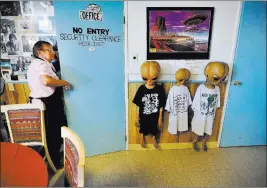  ?? DAVID BECKER/ LAS VEGAS REVIEW-JOURNAL ?? Pat Travis, owner of Little A’Le’Inn in Rachel, opens her office door next to a wall of alien dummies Aug. 5. The business offers a variety of Area 51 and UFO-themed items for sale.