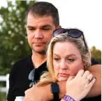  ??  ?? (Right) Robert Bell holds Jennifer Bell as they mourn during the vigil in honor of the victims of the Las Vegas shooting.