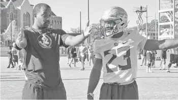  ?? JOE REEDY/ASSOCIATED PRESS ?? FSU running backs coach Donte’ Pimpleton, left, directs Cam Akers during the team’s first spring practice in March.