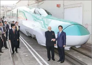  ?? AFP/JIJI PRESS ?? India’s Prime Minister Narendra Modi and his Japanese counterpar­t Shinzo Abe (right) shake hands in front of a Shinkansen train on November 12.