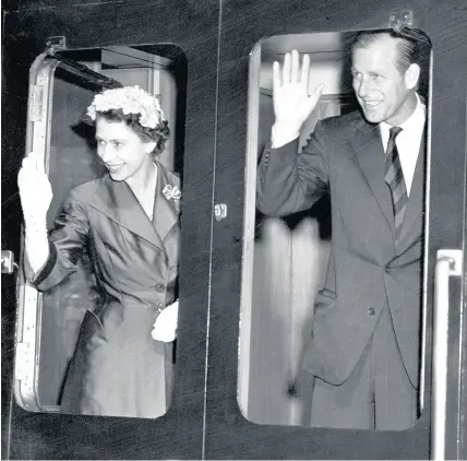  ?? Staff ?? > The Queen and Prince Philip wave from a train during a visit to Wales in August 1955