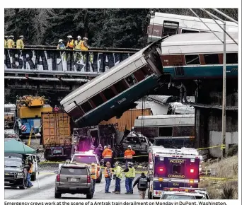  ?? STEPHEN BRASHEAR / GETTY IMAGES ?? Emergency crews work at the scene of a Amtrak train derailment on Monday in DuPont, Washington. At least six people were killed when a passenger train car plunged from the bridge. The derailment also closed southbound I-5.