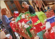  ?? MEDIANEWS GROUP FILE PHOTO ?? Volunteers from local churches place holiday items in colorful gift bags for children in the Pottstown Cluster of Religious Communitie­s toy and clothing drive.