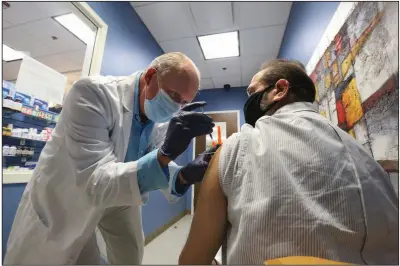 ?? (Arkansas Democrat-Gazette/Thomas Metthe) ?? Pharmacist Edward “Burk” Buerkle gives Hugh Finkelstei­n his second vaccine dose Friday at Freiderica Pharmacy and Compoundin­g in Little Rock.