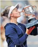  ?? SARAH MEYSSONNIE­R • REUTERS ?? Czech Republic’s Barbora Krejcikova celebrates with the trophy after winning the women’s singles final match at the French Open against Russia’s Anastasia Pavlyuchen­kova on Saturday. She then teamed up with Katerina Siniakova to win the event’s women’s doubles title at Roland Garros in Paris on Sunday.