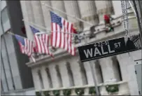  ?? MARY ALTAFFER — THE ASSOCIATED PRESS ?? The Wall St. street sign is framed by U.S. flags flying outside the New York Stock Exchange in New York in January 2020.